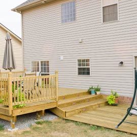 a wood deck patio with steps and fence for a home backyard