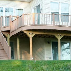 large backyard wood deck with stairs and fence