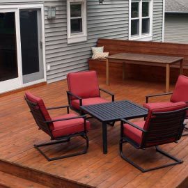 chairs and table on on wood deck patio for a home backyard